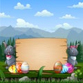 Happy Easter bunnies with Easter eggs by a wood sign board Royalty Free Stock Photo