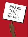 Black hand holding a PRO BLACK ISNÃ¢â¬â¢T ANTI WHITE protest placard