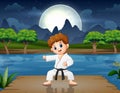 A boy practicing karate on the pier at night