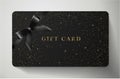 Gift card with twinkling stars, sparkling elements and bow ribbon on black background Royalty Free Stock Photo