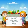 Two kids holding a sign text of World Vegan Day