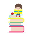 Cute little boy sitting and reading a book on stack of books, happy pupil reading a book at a top of a books heap Royalty Free Stock Photo