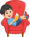 Cartoon little boy reading a book on sofa Royalty Free Stock Photo