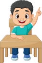 Cartoon little boy sitting on table with pointing up