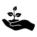 Silhouette of a hand carrying a plant to be planted.