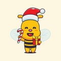 Cute bee holding christmas candy and gift. Royalty Free Stock Photo