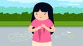 Little girl in a pink T-shirt stands in the park and cries.