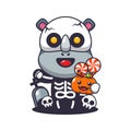 Cute rhino with skeleton costume holding halloween pumpkin.