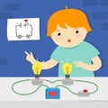 A boy assembles an electrical circuit with light bulbs.