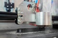 Modern 3D printer machine printing plastic model at trade show - close up view