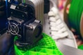 print head of 3D-printer makes a shoe sole with distinct inner structure from bright green plastic filament. Royalty Free Stock Photo