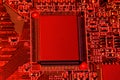 Printed circuit board and microchip, or cpu, in red light closeup - electronic component for digital equipment, concept for Royalty Free Stock Photo