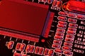 Printed circuit board and microchip, or cpu, in red light closeup - electronic component for digital equipment, concept for Royalty Free Stock Photo