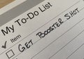 Printed to-do list with checkboxes and single task - get booster shot