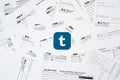 Printed Tumblr logo on many tax form blanks lies on table close up. Help with tax problems using internet and information from