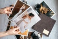 Printed wedding photos with the bride and groom, a vintage black camera, photoalbum and woman hands with two photos Royalty Free Stock Photo