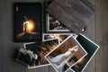 Printed wedding photos, wooden box, a vintage black camera and a black tablet with a picture of a wedding couple