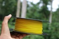 Printer filament made from Bio plastic held in hand with nature on background to show concept of eco friendliness since material