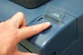 Printing machine control panel with start buttons. Worker`s hand, finger pushing the power button. Royalty Free Stock Photo