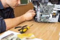 printer repair technician. A male handyman inspects a printer before starting repairs in a client's apartment. Royalty Free Stock Photo