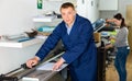 Printing employee cuts paper on a roller cutter machine Royalty Free Stock Photo