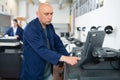 Printing house employee works on printing equipment Royalty Free Stock Photo