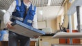 Printing worker carries a stack of paper