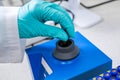 Prior to HPLC analysis, a chemist shakes samples using a vortex mixer.