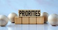 PRIORITIES - word on wooden cubes on a light background with balls Royalty Free Stock Photo