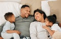Prioritising healthy bonding. a beautiful young family talking and bonding in bed together.