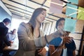 Prioritizing tasks for their project. coworkers arranging sticky notes on a glass wall during a brainstorming session.