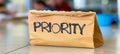 Priority small brown envelope on white surface with prominently displayed priority text Royalty Free Stock Photo