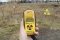 Close up to a geiger counter with radiation levels and a radioactive logo sign at background at chernobyl