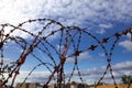 Prison. Barbed wire. Barbed wire on blue sky background with white clouds. Wire boom. Military conflict . Syria. Royalty Free Stock Photo