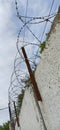 Prison fence enclosing a restricted area barbed wire against the blue sky