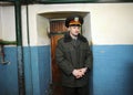 Prison guard standing in a prison hallway in front of a door of a cell. Lukyanivska detention facility. Kyiv, Ukraine