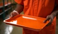 A prison inmate holding an empty canteen food tray