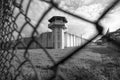 Prison watchtower protected by wire of prison fence.White prison wall and guard tower with coiled barbed wire.Criminal justice Royalty Free Stock Photo