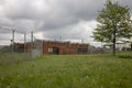 Priso with razor wire on fence with overgrown yard