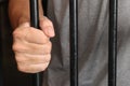 Prisoner behind bars.hand of prisoner on steel jail bars.Man under arrested by policeman because illegal behaviour Royalty Free Stock Photo