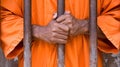 Prisoner behind bars. Male hands close-up.