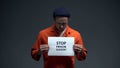 Prisoner holding Stop prison slavery sign, human rights protection, violence