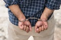 Prisoner man in jail with handcuffs. Close up Shackled in Hands