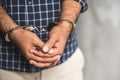 Prisoner man in jail with handcuffs. Close up Shackled in Hands