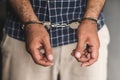 Prisoner man in jail with handcuffs. Close up Shackled in Hands