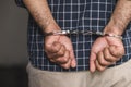 Prisoner man in jail with handcuffs. Close up Shackled in Hands