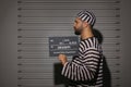 Prisoner with mugshot letter board at police department