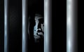 Prisoner and prison cell. Alone in jail behind bars. Felony committed crime or bankrupt. Business criminal serve their sentence in Royalty Free Stock Photo