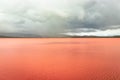 Pristine landscape with red lake calm water and dramatic sky at morning