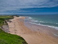 The pristine sand of Whiterocks Beach and coastal cliffs on the Antrim Causeway Coast in Northern Ireland, UK. Taken on a sunny Royalty Free Stock Photo